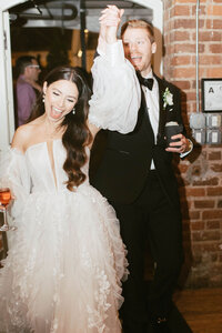 bride and groom make joyful entrance into wedding reception