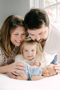 Family looking down at sleeping newborn baby