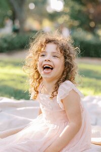 little girl laughing at camera
