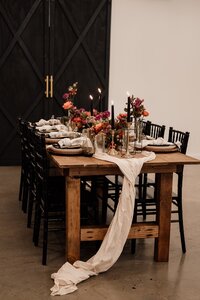 wedding table with florals, oak table with black chiavari chairs