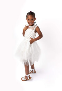 Child in white dress posed against clean studio backdrop in Eastern North Carolina