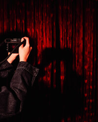 Creative portrait photographed with dramatic red studio lighting by Mewphotovideo.