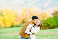 Devin kissing cheek of his new fiancee in New England field proposal