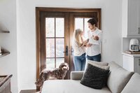 Relaxed lifestyle photographer capturing the joy and innocence of a newborn baby in natural light with parents and pet dog.