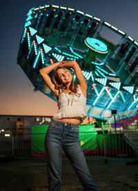 Senior portrait at the Greater Gulf State Fair in Mobile, Alabama — standing in front of the Tilt-A-
Whirl with blue lights glowing.