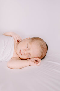 newborn baby boy wrapped in a white swaddle