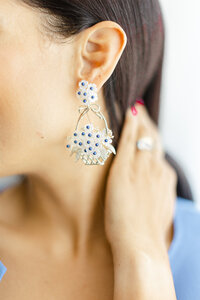 Close up headshot/branding portrait of a lady holding the back of her neck while she shows off her earing.