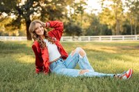 Senior portrait in downtown Magnolia Springs, Alabama — posing in the grass.