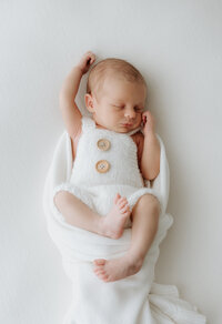 Newborn baby cradled in loving hands during an intimate indoor session in Perth
