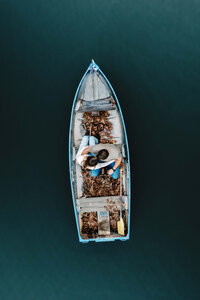 An artistic top-down capture of a couple in a rowboat, emphasizing intentional imagery and the quiet, real moments of the weekend.