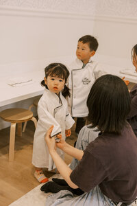 Little girl getting her chef's coat on for culinary class at The Bunny Hive Mountain View