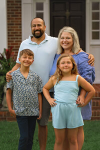 Family of four smiling during outdoor portrait session in coastal North Carolina