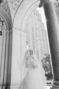 black and white image of bride looking out out in archway with veil over her in detroit