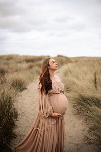 Pregnant woman posing on Maternity Photoshoot in Hawkes Bay Ocean Beach with Lightkeeper Photography
