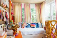 A colorful  interior design studio with day bed and swatches on the walls.