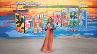 Allie Cline standing in front of the New Bern North Carolina mural
