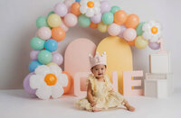 Cake Smash Photographer in Charleston, SC - Baby smiles at the camera during Cake Smash Photoshoot at Holy City Babies in Charleston, SC.
