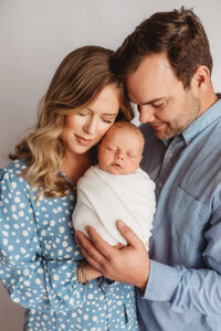 Newborn Pictures in Charleston - Infant posed with his family during Newborn Pictures at Holy City Babies Newborn Photography Studio in Charleston, SC.