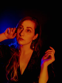 Cinematic portrait of Morgan Wright illuminated by dramatic orange and blue light.