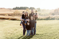Extended family group standing together in a field during a Cleveland family photography session
