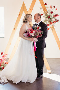 After a February wedding at an up and coming venue, a Duluth wedding photographer captures the happy newlyweds with their Valentine themed florals.