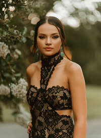Senior Portrait at Triple T Farms in Fruitdale, Alabama — wearing a black lace dress in front of greenery.
