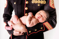 Newborn baby cradled in parent’s hands in studio session in New Bern NC