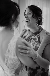 Instant complice et rempli d’émotion entre la mariée et une amie proche pendant les préparatifs du mariage, capturé en noir et blanc par Jeff Gagnon photographe.