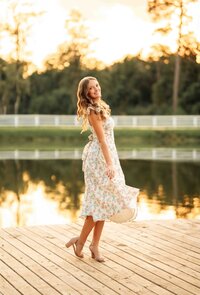 Senior girl twirling in a floral dress at The Oaks at Magnolia Springs in Magnolia Springs, Alabama.