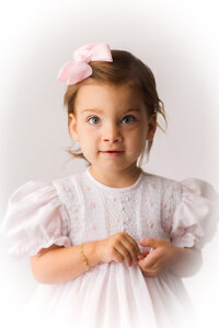 Little girl smiles at the camera during Heirloom Portrait Photography Session in Charleston, SC Photo Studio.