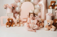 Charleston Cake Smash Photographer- Baby looks into the camera during Cake Smash Photos at Holy City Babies Portrait Studio in Charleston, SC.