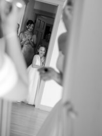 Detroit MI Wedding Photography of a bridesmaid and flower girl watching the bride get ready.