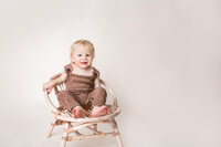 Young boy in brown outfit seated in studio portrait session in New Bern NC