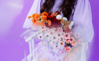 Colorful floral styling photographed against a purple backdrop for a singer-songwriter visual identity