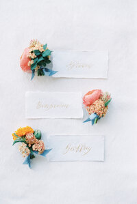 three bundles of flowers next to wedding party names