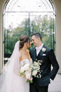 Bride and groom embrace nose to nose and smile on their wedding day