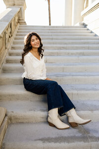 High school senior girl sitting on stone steps in a downtown setting, natural light senior portrait by Kaitlyn Dawn Photography, Inland Empire senior photographer.