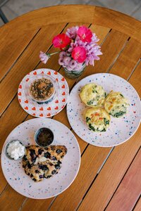 Breakfast spread with egg frittatas, a blueberry scone, and a yogurt parfait.