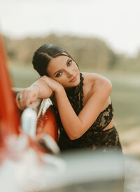 Senior portrait at Triple T Farms in Fruitdale, Alabama — close-up leaning against the red truck.