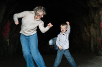 Mom and son dancing in a dark cave