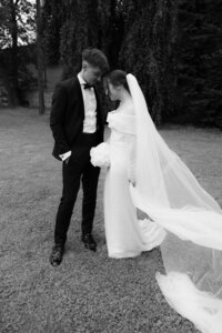 Bride in beatifull white dress and groom in stylish tuxedo posing for documentary wedding photographer Lucie Muse