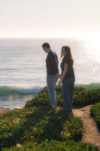 Sunset sparkling ocean couple engagement photos on aptos cliffside