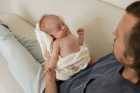 dad-newborn-chest-cream-sofa-looking-down-in-home-boulder-photographer-199