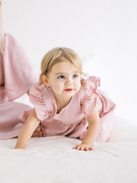 Closeup of a toddler girl wearing a ruffly pink dress