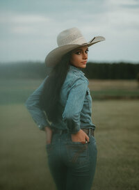 Senior portrait at Triple T Farms in Fruitdale, Alabama — hands in back pockets, looking back
toward the camera.