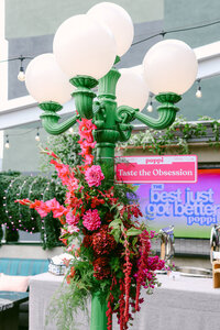Large-scale floral installation photographed at a branded event, highlighting event design and visual storytelling