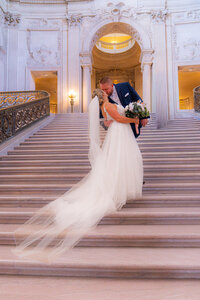 san francisco city hall bride and groom kissing on romantic fairytale stair