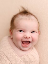 Happy baby smiling during a baby photography session in Salem, Oregon.