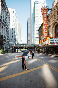 Newlyweds kissing in front of iconic Chicago Theatre marquee sign after City Hall wedding