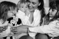 A woman holds children closely